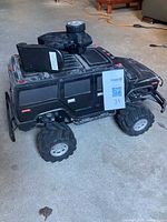 Side view of black Hummer-style R/C truck with controller resting in cargo bed