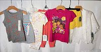 Group shot of all seven clothing items on hangers