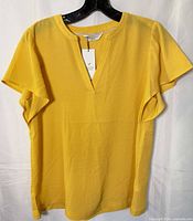 Front view of yellow Denver Hayes blouse on hanger