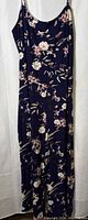 Full front view of navy floral jumpsuit on hanger