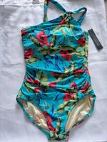 Front view of tropical print one-piece swimsuit with tags