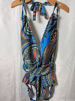 Front view of blue paisley one-piece swimsuit on hanger