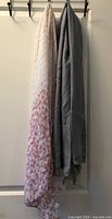 Two scarves hanging, showing colors and patterns