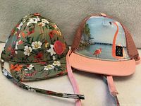 Front view of both infant hats showing designs