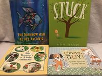 Group shot of all four children’s books standing upright