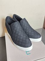 Pair of quilted slip-on wedge sneakers on box