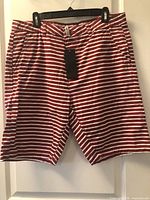 Front view of red and white striped Cotone shorts with tag attached