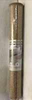Rolled bath mat in clear tube showing label and woven pattern