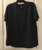 Front view of black TGP workout top on hanger