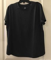 Front view of black women’s workout top on hanger