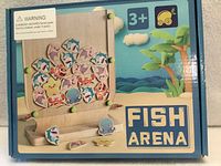 Front of unopened Fish Arena game box showing wooden stand and fish pieces