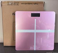 Pink scale front view leaning on box
