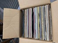 Open box of vertically stacked LPs showing spines