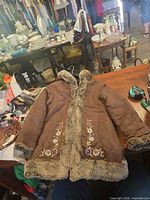 Front view of brown hooded coat showing faux fur trim and floral embroidery