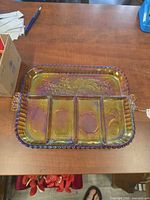 Top view of iridescent divided tray showing four compartments and fruit motif