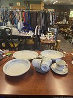Full set laid out on table showing cups, saucers, bowls and platters