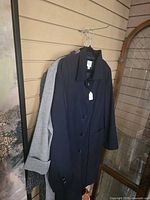 Navy coat front view with grey and tweed jackets partially visible