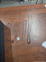All five necklaces laid out showing overall designs and lengths
