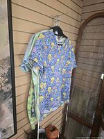 Five scrub tops hanging, showing variety of prints and colors