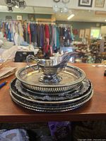 Stacked silver-plated trays with gravy boat on top