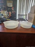 Both casserole dishes side by side on desk showing relative sizes and pattern