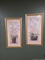 Both framed orchid artworks side by side
