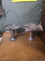 Full view of both silver-plated bridal baskets on pedestal bases