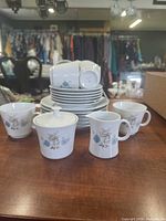 Front view of full set showing cups, saucers, sugar bowl with lid, and creamer