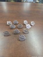 Front view of all 11 Onion Ring Olympics pins spread on table