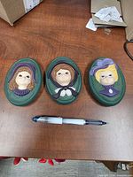 All three plaques with pen for scale