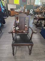 Front view of wooden armchair showing seat, arms and legs