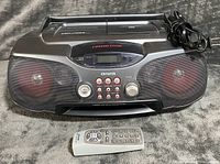 Front view of Aiwa boombox with remote and AC cord visible