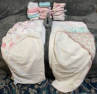 Overview of two hooded towels, stacked washcloths and gray rinse cup
