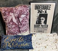 Overall lot showing packaged duvet cover, sheet set, Expecto Patronum pillow and framed Undesirable No.1 poster