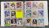 Binder open showing two pages of Fleer ’90 football cards in nine-pocket sleeves