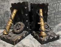 Front view of both bookends showing cannons, wheels, chains and wood texture