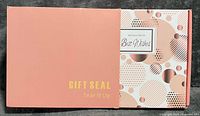 Outer pink gift sleeve and box showing design and labels