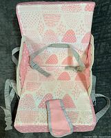 Front view showing patterned seat, harness, and carry strap