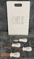 Front view of ceramic board showing CHEESE text and four cheese tools
