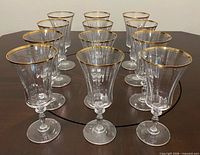 Front angled view of all 12 goblets showing gold rims and stem design