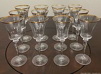 Front angled view of all 12 wine glasses displaying gold rims
