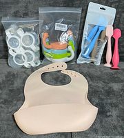All items grouped: bib, spoons/spatulas, snack bowls, ring holders in packaging