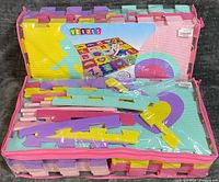 Zippered clear bag containing stacked pastel interlocking foam tiles with Verdes branding visible
