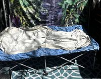 Blue folding cot with cream air mattress set on top