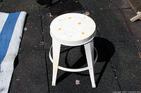 full view of white metal stool on ground