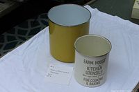 Yellow and cream enamel metal utensil holders side by side