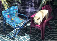 Blue folding camping chair and pink plastic chair side by side