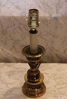 Full view of brass candlestick lamp showing socket, body, and cord