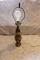 Full view of brass table lamp with harp and bulb