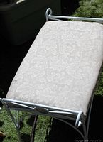 Top view showing cream damask cushion and white iron frame